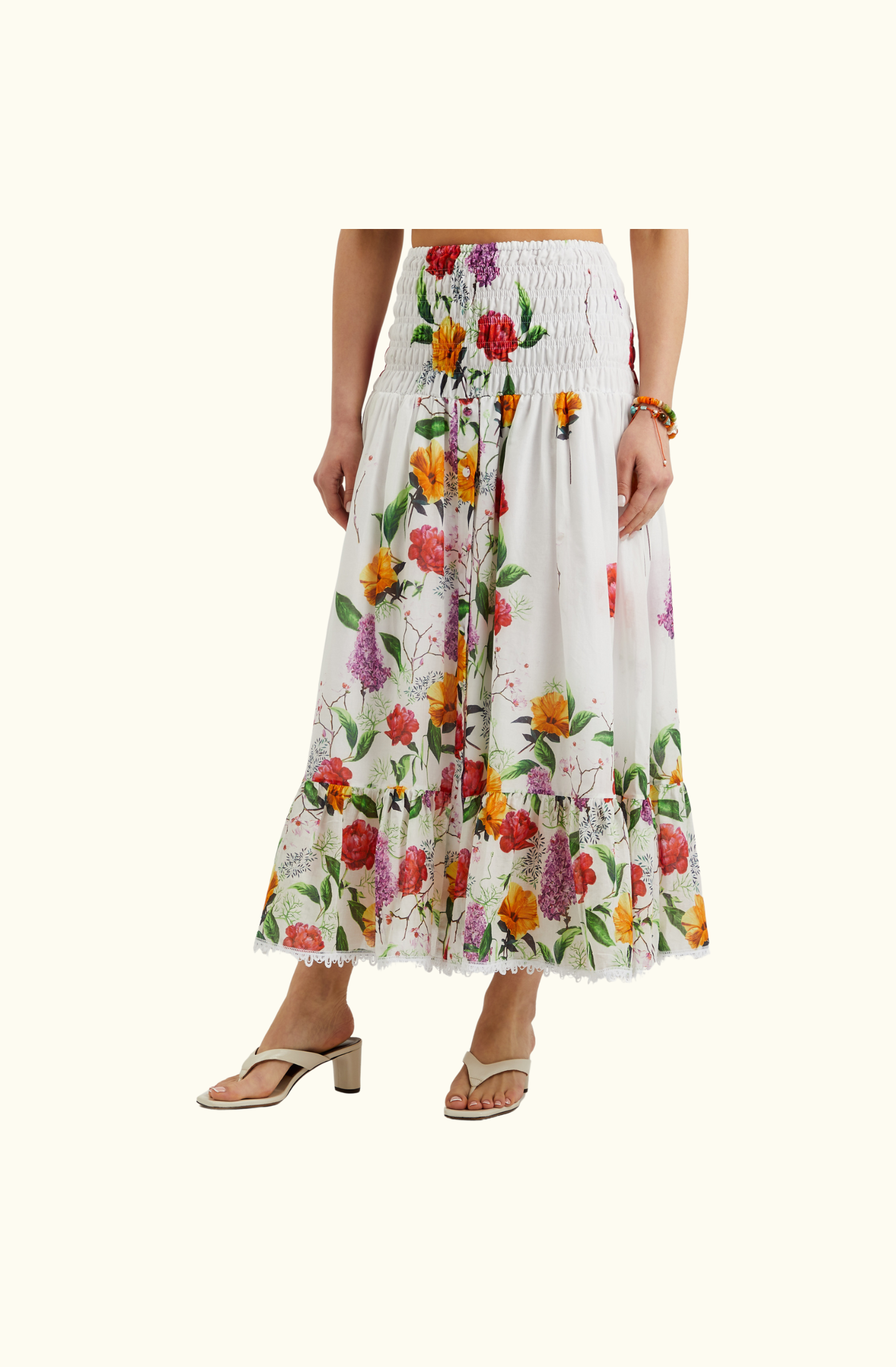 Close-up of the floral maxi skirt from the Charo Ruiz Ibiza co-ord set, showing the smocked waistband, front button detail, and scalloped lace hem.