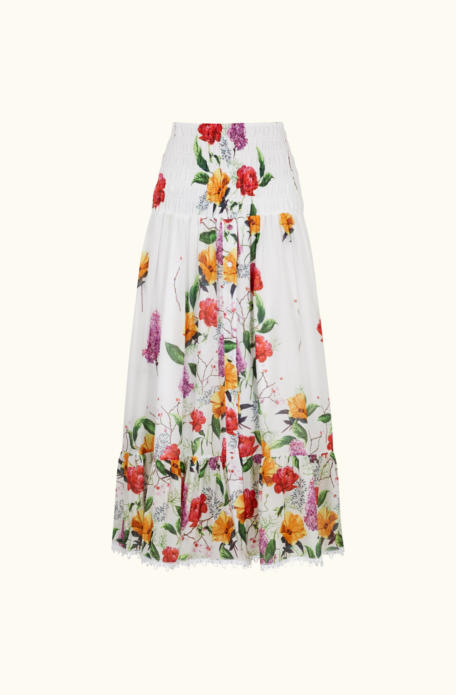 Close-up of the floral maxi skirt from the Charo Ruiz Ibiza co-ord set, showing the smocked waistband, front button detail, and scalloped lace hem.