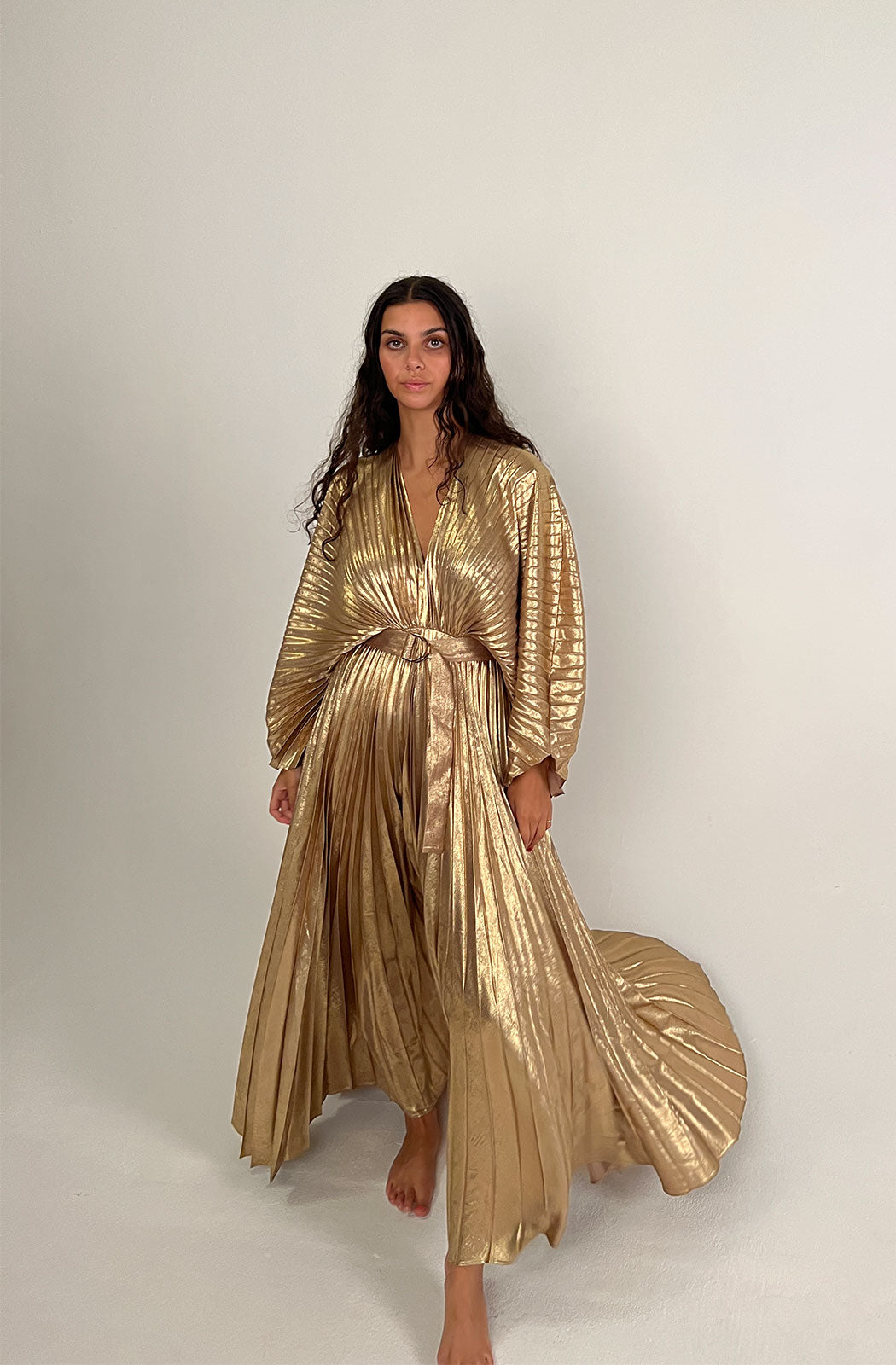 Acler Women's Natural Westover Dress The Westover Dress in Gold by Acler is a maxi dress crafted in a gold pleated fabrication featuring full length sleeves, a plunging neckline, open back, and statement belt. 100% Polyester.