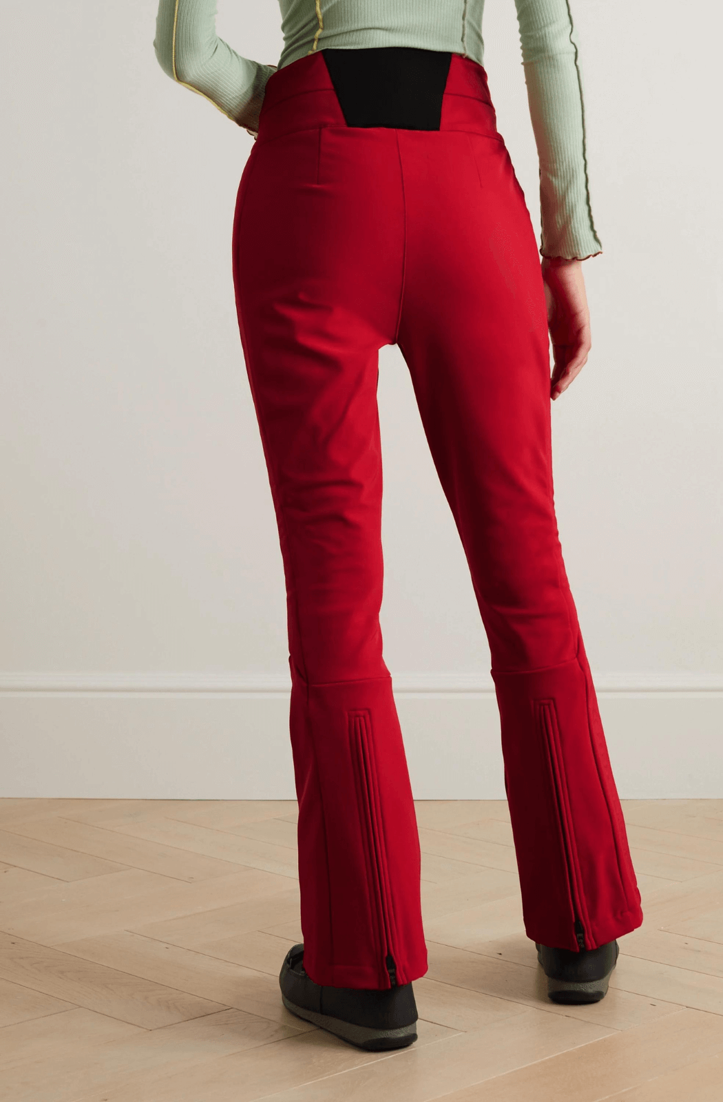 model seen wearing Perfect Moment Aurora Ski Trousers in Red with popper buttons and a high waist
