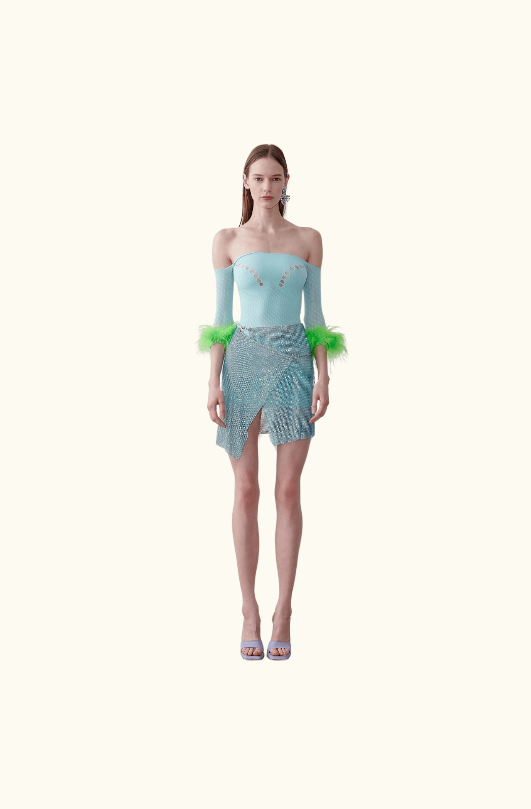 Model wearing the Poster Girl Winona Skirt in Crystallised Cerulean - a shimmering, asymmetrical mini wrap skirt made from rhinestoned micro metal-mesh.