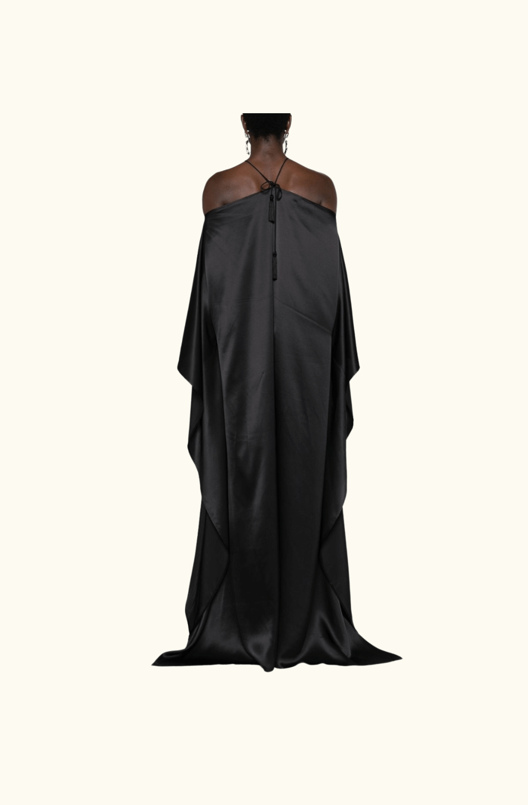 A back view of the Taller Marmo Sza silk maxi dress, showcasing its flowing silhouette, halter tie detailing, and cape-like draped design.