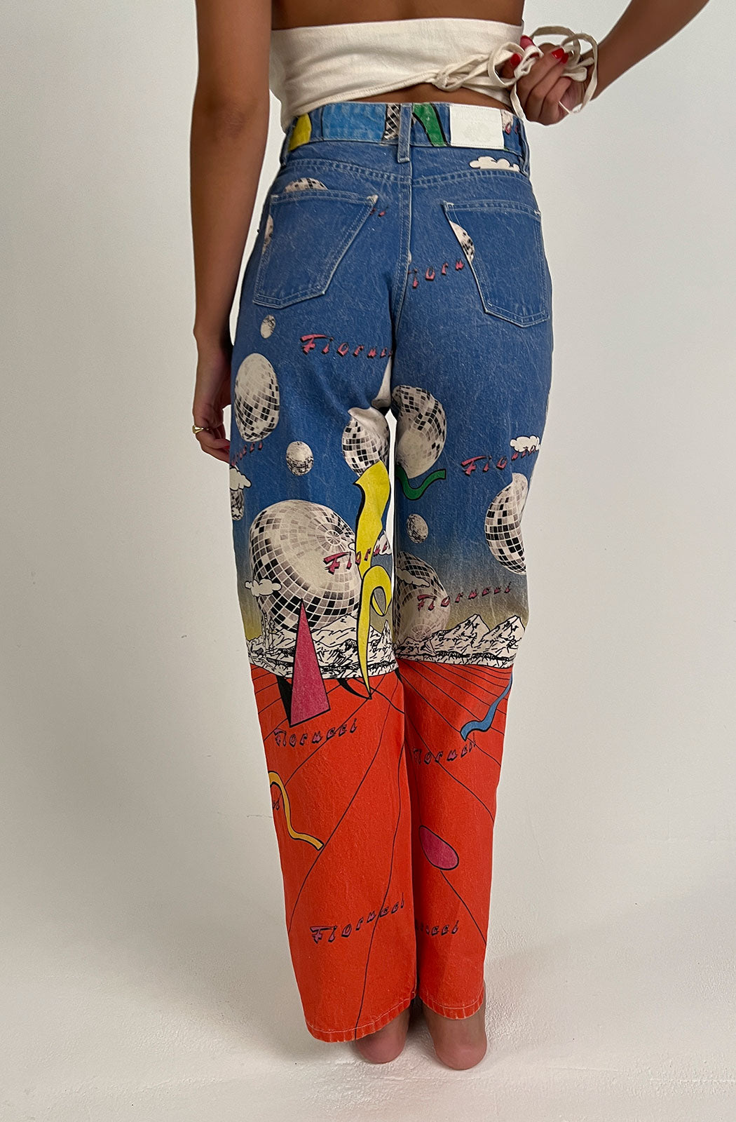 Women's Discoteca Jeans in the all-over multi-coloured discoteca print from the archive. The graphic jeans are high-waisted with a straight leg fit, iconic 5-pocket design, waistband with belt loop and a button and zip fly. Made from hand-crafted, incredibly flattering premium denim. Close up back view