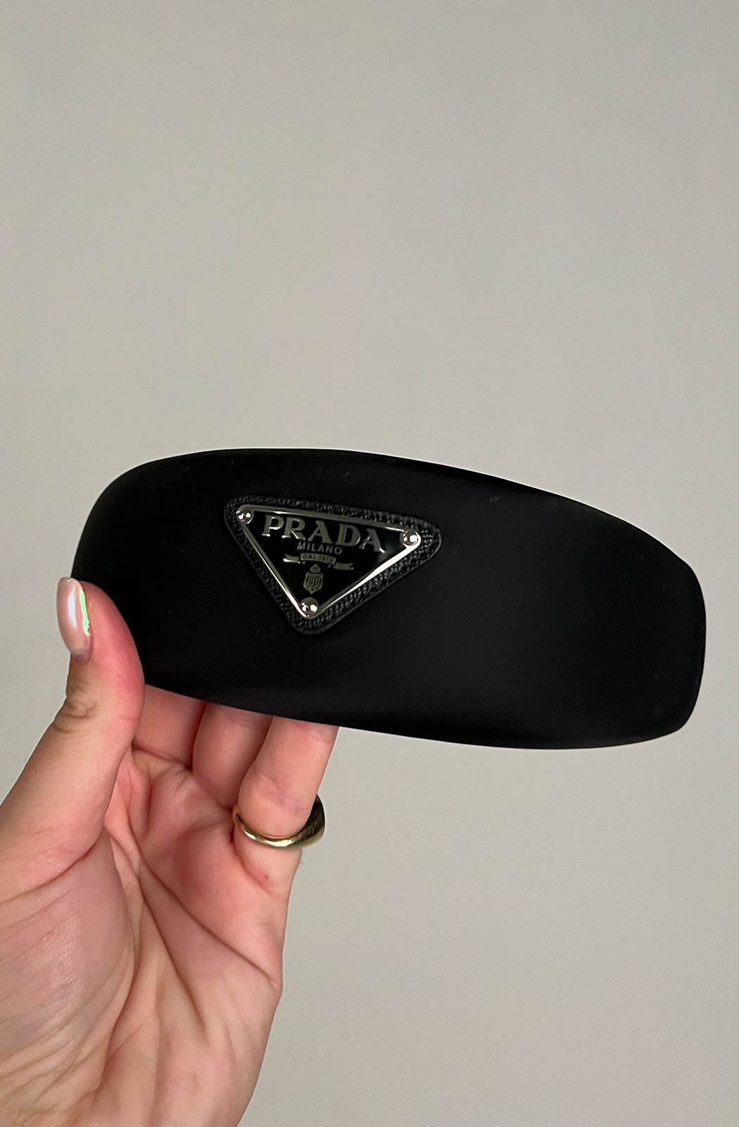 Prada’s black padded Re-nylon headband with triangle logo plaque